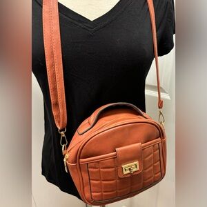 Small satchel crossbody purse with zipper closure.